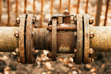 Fragments of old large gas pipe. Rusty brown curved metal iron pipe.