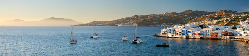 Fototapeta na wymiar Sunset in Mykonos, Greece, with cruise ship and yachts in the harbor
