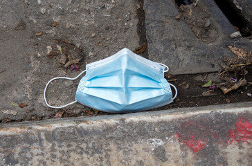 blue medical mask thrown on the street in Athens, Greece
