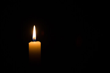 candle burning on black background. concept of faith, memory, prayer, commemoration