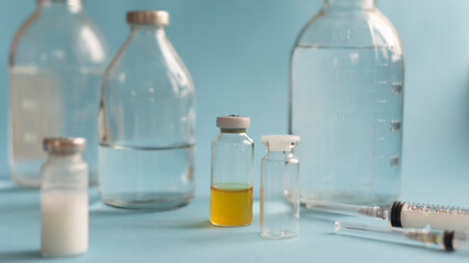 medicine concept, syringe and glass vial with medicine for injection saline dehydration rinsing close-up, blue background with copy space