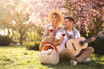 Lovely couple having picnic in park on sunny spring day