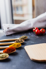 spoons with spices, paprika, basilic, pepper, thyme with cherry tomatoes