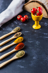 spoons with spices, paprika, basilic, pepper, thyme with cherry tomatoes