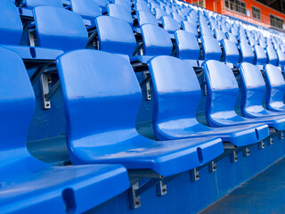 Empty stands in a stadium or sports field. The stands for the fans are blue. Without fans and fans