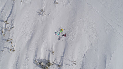top view of snow angels on a snow field in the mountains. snow angel - a man lies in the snow with his arms and legs outstretched by a star