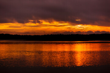 Fototapeta na wymiar Beautiful sunset on the lake among the trees