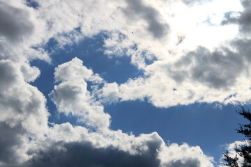 White clouds block out the sun. The blue sky slips through the clouds.