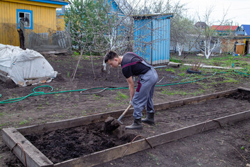young guy digging a garden bed