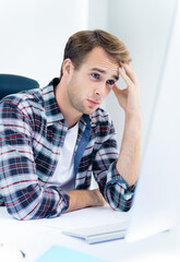 Thinking man in smart casual wear, working with desktop computer, indoors. Business, job and education concept image.