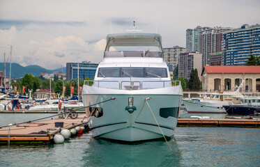 White yacht stands in the port, front view, close-up