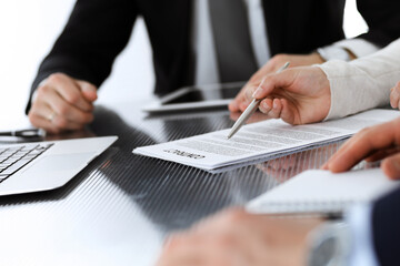 Business people discussing contract working together at meeting in modern office. Unknown businessman and woman with colleagues or lawyers at negotiation