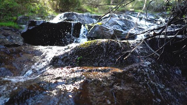 Slow motion of waterfall with the water falling slowly between the rocks in the forest. Navacerrada Madrid.