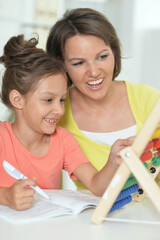 Portrait of a beautiful little cute girl reading book with mother