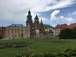 Fototapeta na wymiar The Parish House and the Wawel Cathedral on Wawel Hill: Sigismund's Chapel (right, with a gold dome) and Vasa Dynasty chapel (to the left) in Krakow, Poland