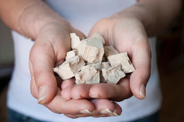 Woman shows her hands full of brewer's yeast