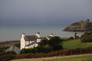 A Winter view over Cardigan Bay showing  a farmhouse and Criccieth Castle., Wales.