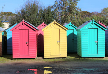 Fototapeta na wymiar Colourful beach huts removed from the beach and placed in a carpark for the winter at Llanbedrog, Gwynedd, Wales, UK.