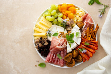 Charcuterie assortment, variety of cheeses and salami, prosciutto and dried fruits, figs, apricots,...