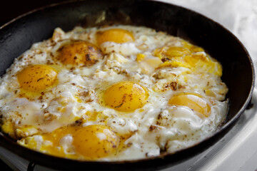 Scrambled eggs with spices are cooked in a skillet.
