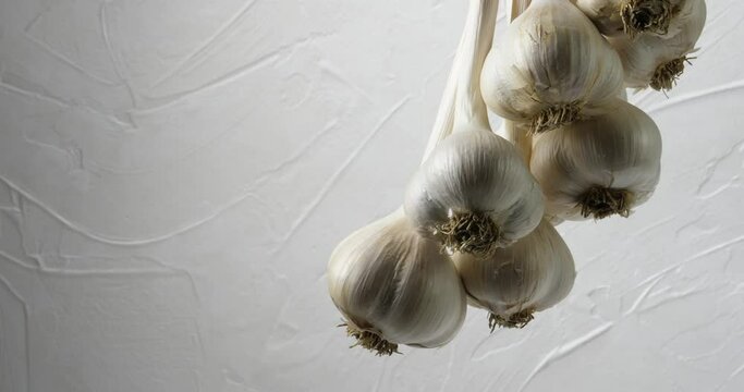 The harvest of a bunch of garlic hung drying and spinning slowly