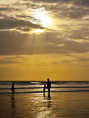 Father with children at sunset on beach