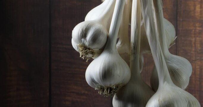 The harvest of a bunch of garlic hung drying and spinning slowly