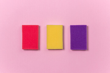 Washing sponges on a pink background. Cleaning sponges on a colored background. Indoor washing and cleaning tools.