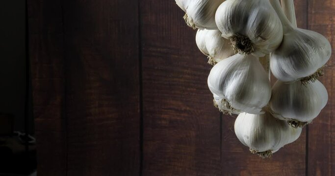 The harvest of a bunch of garlic hung drying and spinning slowly