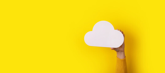cloud in hand over yellow background, storage concept, panoramic image