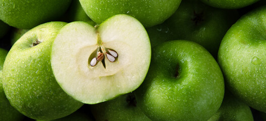 half apple on whole green apples background, panoramic image