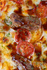 Pizza with mushrooms, sausage and olives on a wooden background