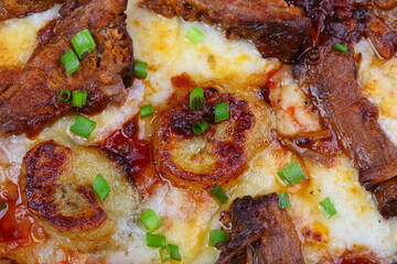 Pizza with mushrooms, sausage and olives on a wooden background