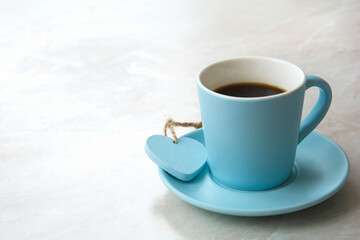 a cup of coffee with a heart on a light blurred table background