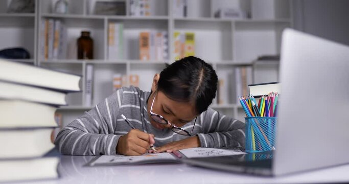 Happy girl typing on laptop and doing homework.