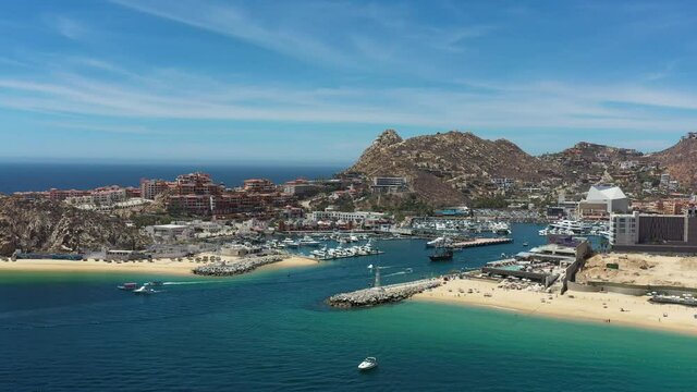 Aerial panoramic view of the Marina in Cabo San Lucas, the drone flying in El Medano Beach with a blue sky as background.