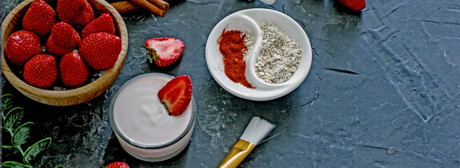 Ingredients homemade strawberry face mask, cream, strawberry, oatmeal, spices, herbs on a dark background, top view, copy space, flat lay, banner. Home hand-made cosmetics made from natural ingredient