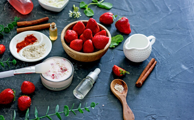Ingredients homemade strawberry face mask, cream, strawberry, oatmeal, spices, herbs on a dark background, top view, copy space, flat lay/ Home hand-made cosmetics made from natural ingredient