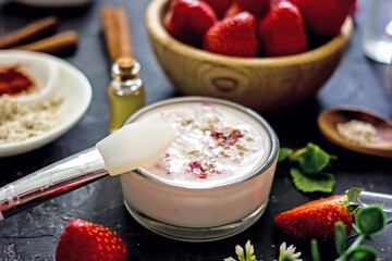 Homemade strawberry face mask with oatmeal and cream on a dark background. Concept of natural handmade cosmetics