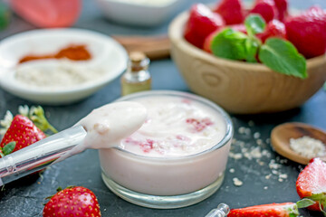 Homemade strawberry face mask with oatmeal and cream on a dark background. Concept of natural handmade cosmetics