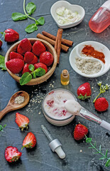 Ingredients homemade strawberry face mask, cream, strawberry, oatmeal, spices, herbs on a dark background, top view, copy space, flat lay/ Home hand-made cosmetics made from natural ingredient