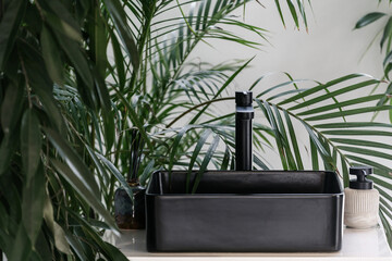 Black matte wash basin in tropical bathroom