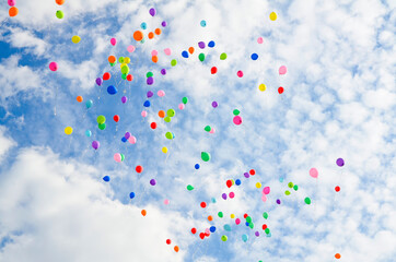 Lots of colorful balloons flying against blue sky with clouds with copy space. Concept of holiday, festival, Children's Day, Last call at school and kindergarten, birthday.