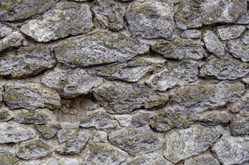 Stone wall made of natural untreated stone. Ancient castle wall