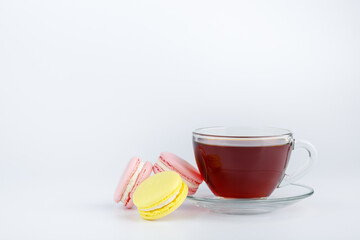 Cup of tea and colorful macaroons on a white background.