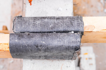 Wooden beams for the partition between the first and second floors are protected with bitumen-based...