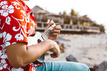 unrecognizable person holding a playing chords with an instrument string called a guitar or...