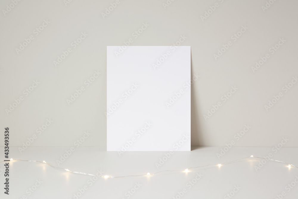 Wall mural festive vertical blank paper mockup template resting against a light brown background wall, with fai