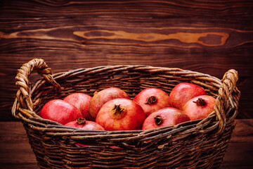 Big wicker wooden basket with pomegranates.
