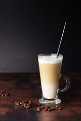 A glass of fresh hot grain coffee with milk-cappuccino or latte on a dark background with a copy of the space.